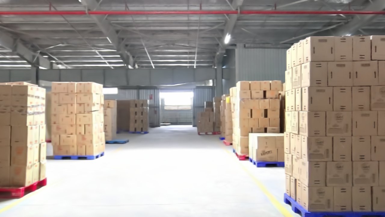 Recreated warehouse with stacked cartons on pallets and open aisles